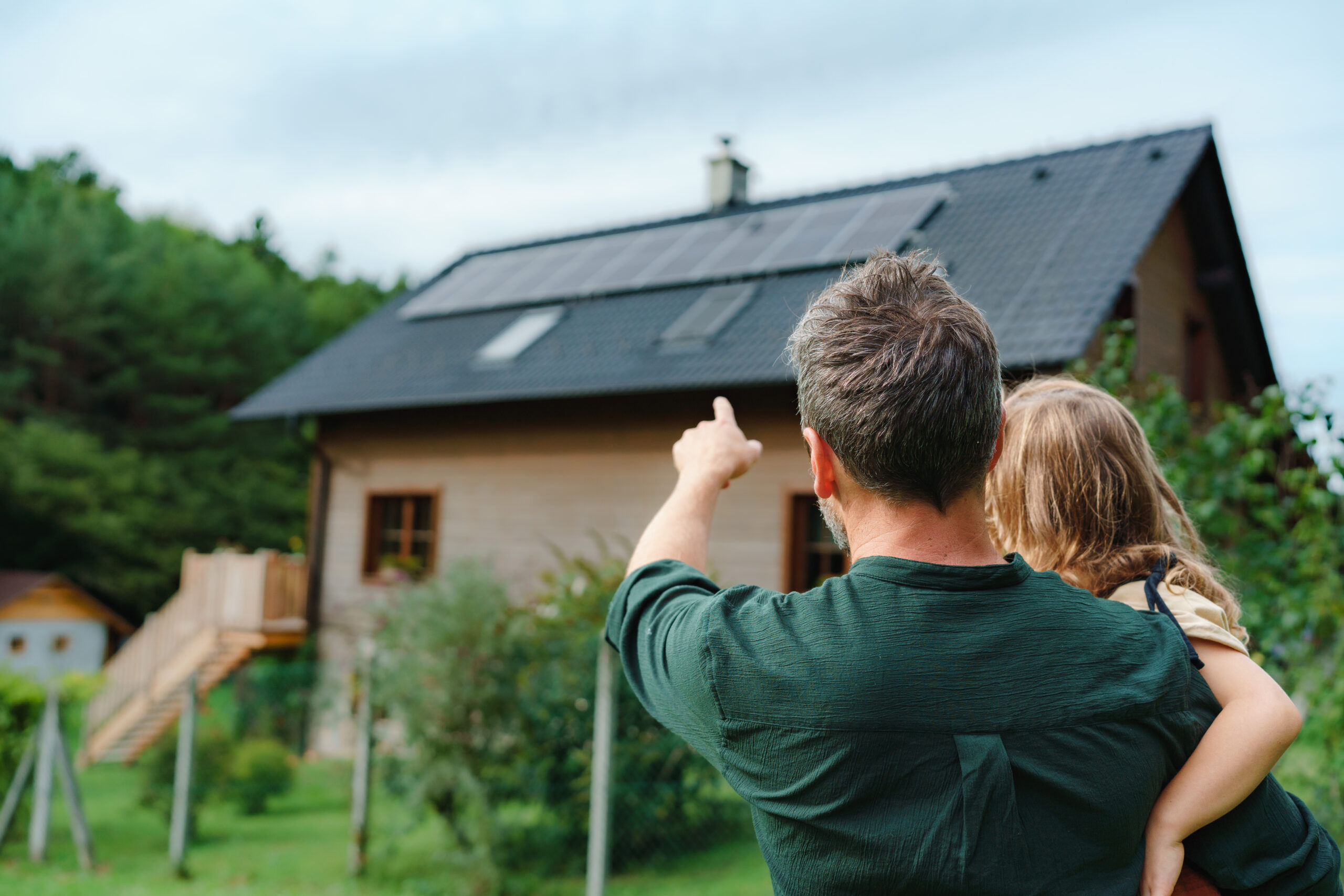 Vader met dochter bij huis met zonnepanelen